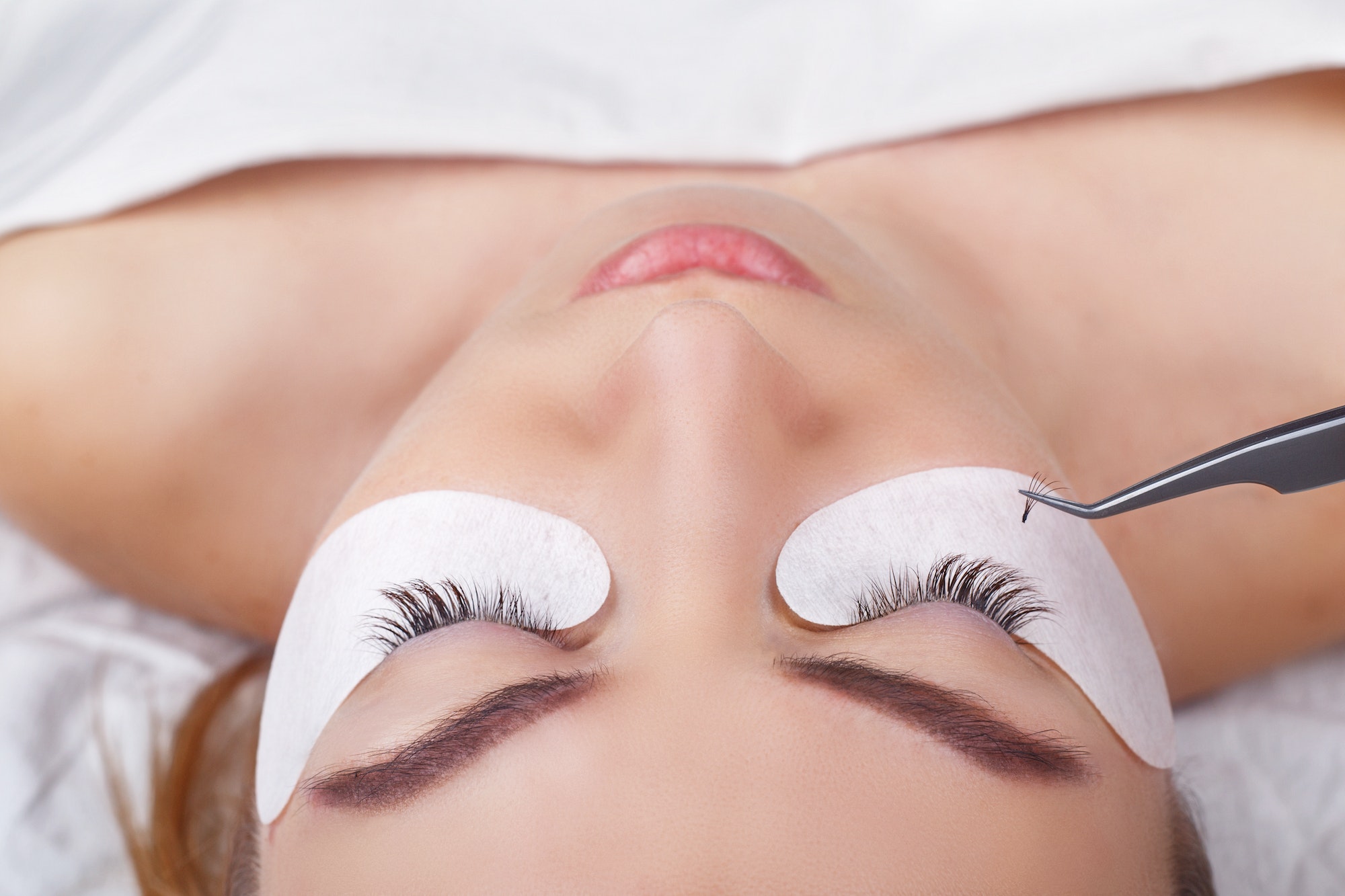 Eyelash Extension Procedure. Woman Eye with Long Eyelashes. Lashes, close up, selected focus